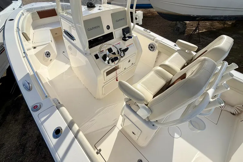 Slide: The Image of 2023 Cobia 262 Center Console boat interior with dual Garmin displays and cushioned seating. - 16