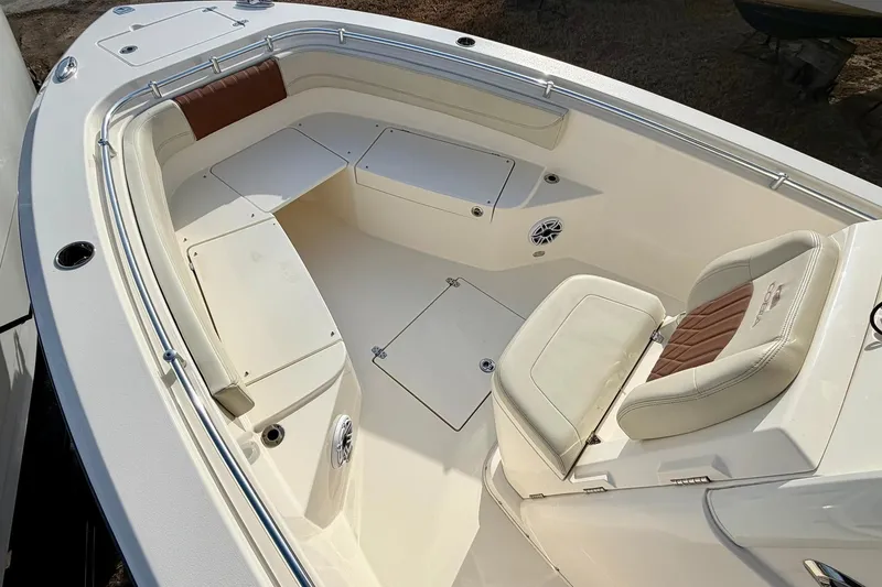 Slide: The Image of 2023 Cobia 262 Center Console boat interior with cushioned seating and storage compartments. - 17