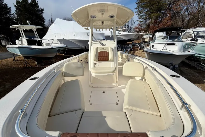 Slide: The Image of 2023 Cobia 262 Center Console boat with spacious seating, parked among other boats. - 21