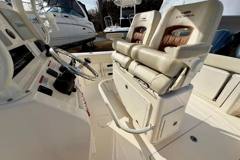 Slide: The Image of 2023 Cobia 262 Center Console boat interior with dual seats and steering wheel. - 27