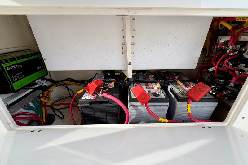 Slide: The Image of 2023 Cobia 262 Center Console battery compartment with wiring and RealPRO charger. - 30