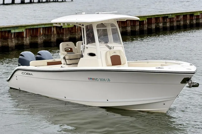 Slide: The Image of 2023 Cobia 262 Center Console boat on water, featuring dual engines and sleek design. - 6