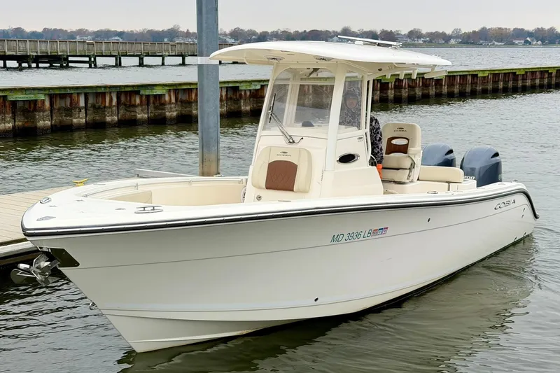 Slide: The Image of 2023 Cobia 262 Center Console boat docked on calm water. - 7