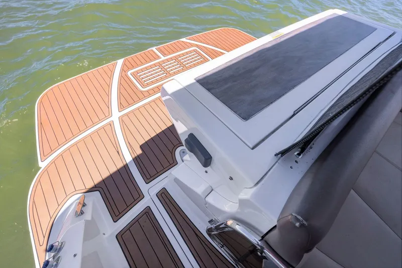 Slide: The Image of 2014 Sea Ray 350 Sundancer swim platform with teak decking on calm water. - 13