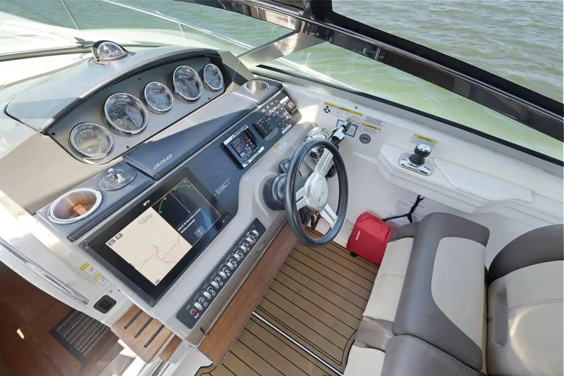 Slide: The Image of 2014 Sea Ray 350 Sundancer helm with modern controls and navigation system. - 19