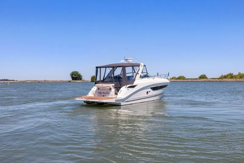 Slide: The Image of 2014 Sea Ray 350 Sundancer cruising on a calm lake under a clear blue sky. - 2