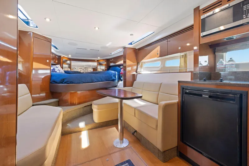 Slide: The Image of Interior of 2014 Sea Ray 350 Sundancer yacht with seating, table, and kitchenette. - 20