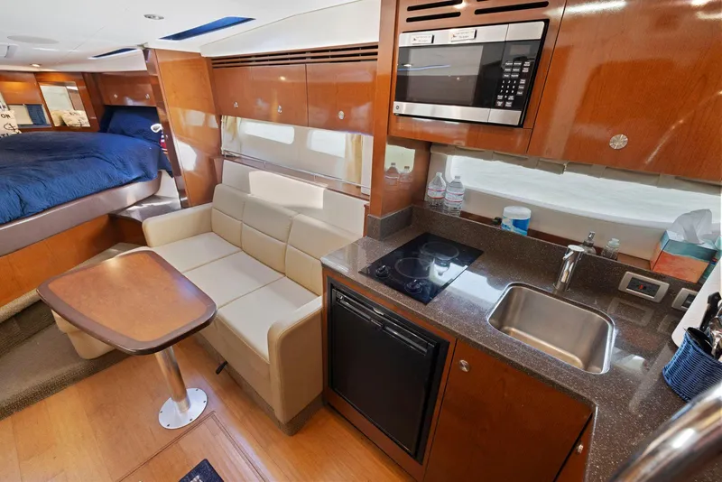 Slide: The Image of Interior of 2014 Sea Ray 350 Sundancer yacht with kitchen, seating, and bed. - 25