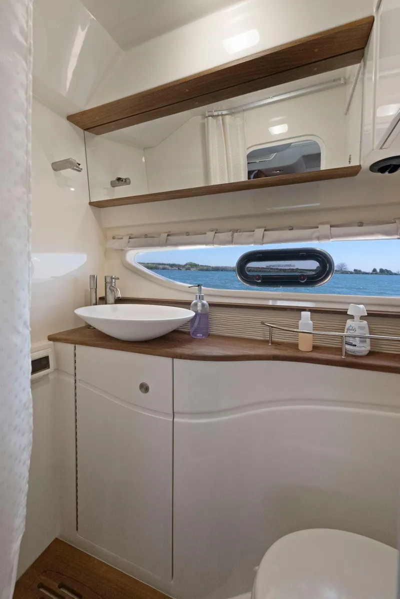 Slide: The Image of 2014 Sea Ray 350 Sundancer bathroom with modern fixtures and ocean view window. - 32