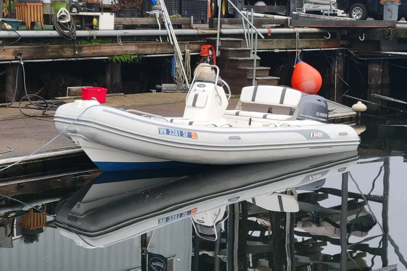 Slide: The Image of 2014 AB Inflatables Oceanus 15 VST boat docked at marina, reflecting on water. - 5