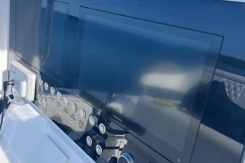 Slide: The Image of 2024 Contender 30 Tournament boat dashboard with Garmin navigation screens and control panel. - 11