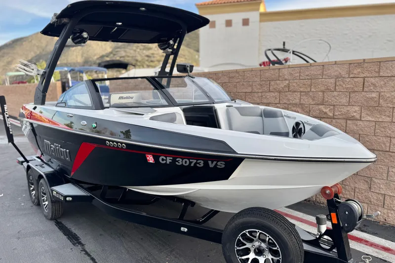 Slide: The Image of 2020 Malibu Wakesetter 22 LSV boat on trailer, sleek design, parked outdoors. - 1