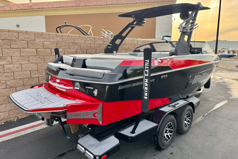Slide: The Image of 2020 Malibu Wakesetter 22 LSV boat on trailer, featuring sleek black and red design. - 5