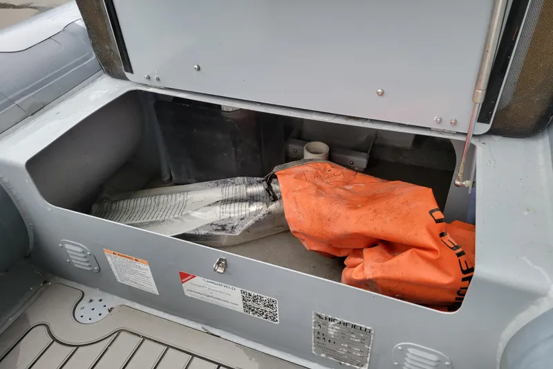 Slide: The Image of 2023 Highfield Sport 360 storage compartment with orange safety equipment and manual. - 15