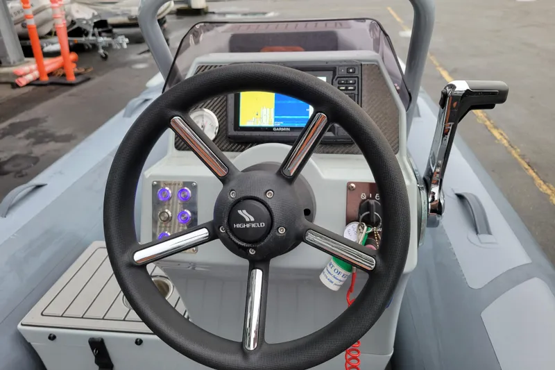 Slide: The Image of 2023 Highfield Sport 360 boat dashboard with steering wheel and navigation display. - 17