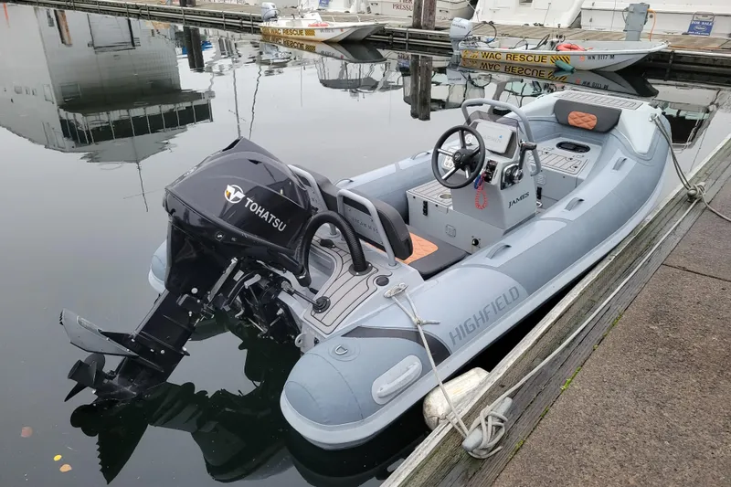 Slide: The Image of 2023 Highfield Sport 360 boat with Tohatsu engine docked at marina. - 2