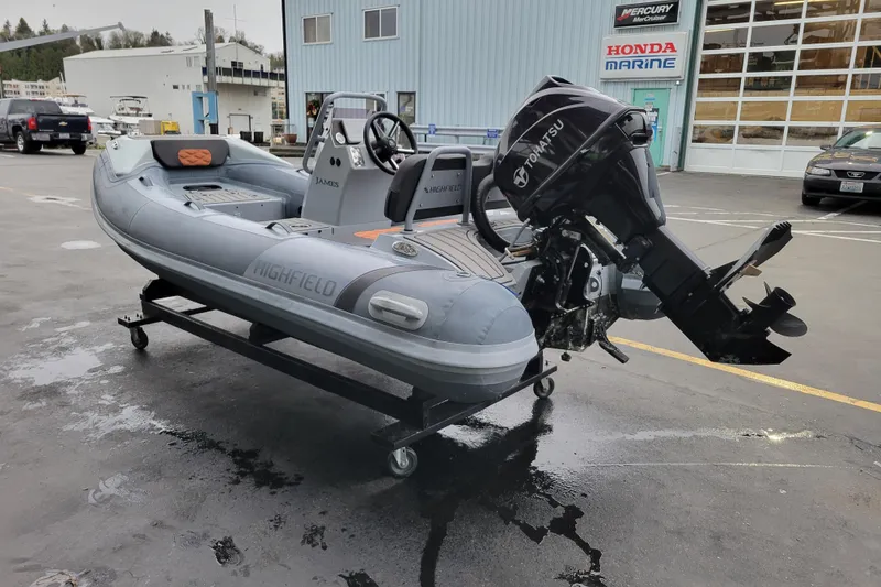 Slide: The Image of 2023 Highfield Sport 360 boat with Tohatsu engine on display at a marina. - 8