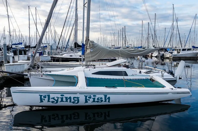 Slide: The Image of 2001 Corsair F-28 CC trimaran "Flying Fish" docked in a marina with sailboats. - 9