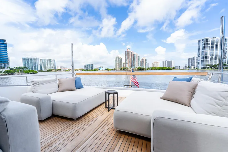 Slide: The Image of Luxurious 2021 Sanlorenzo SX76 yacht deck with modern seating, city skyline view. - 10