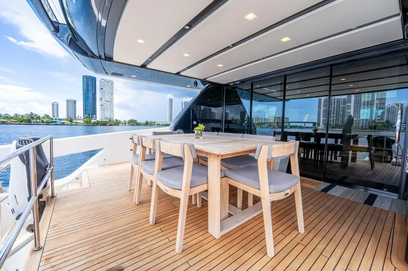 Slide: The Image of Luxurious 2021 Sanlorenzo SX76 yacht with elegant outdoor dining area and city skyline view. - 21