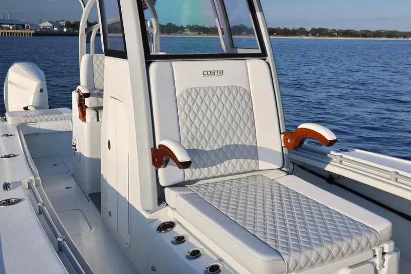 Slide: The Image of 2024 Costa Custom Boats 264 HC with luxurious seating on calm waters. - 17
