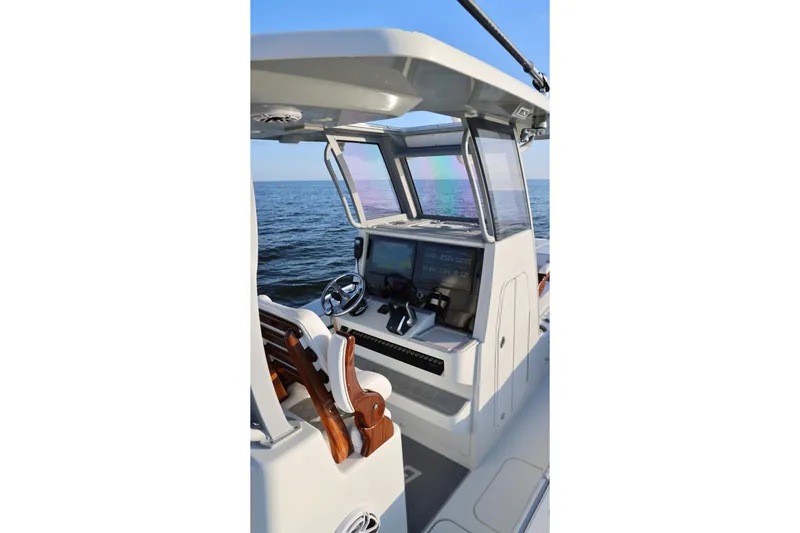 Slide: The Image of 2024 Costa Custom Boats 264 HC helm with advanced navigation system on open water. - 23