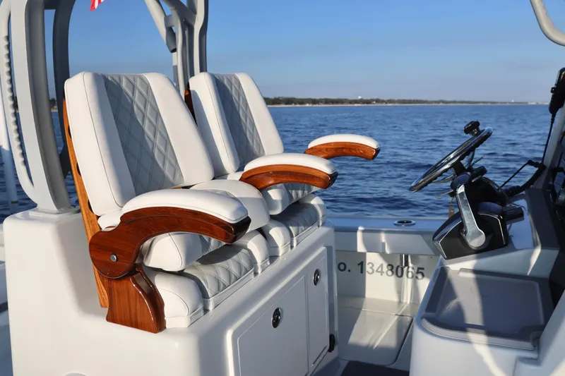 Slide: The Image of 2024 Costa Custom Boats 264 HC interior with luxurious seating and steering wheel, ocean backdrop. - 24