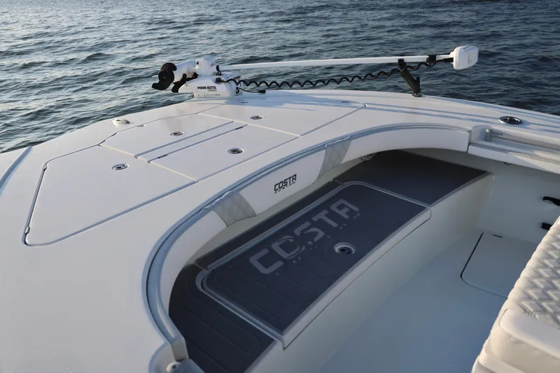 Slide: The Image of 2024 Costa Custom Boats 264 HC deck with Minn Kota trolling motor on water. - 29