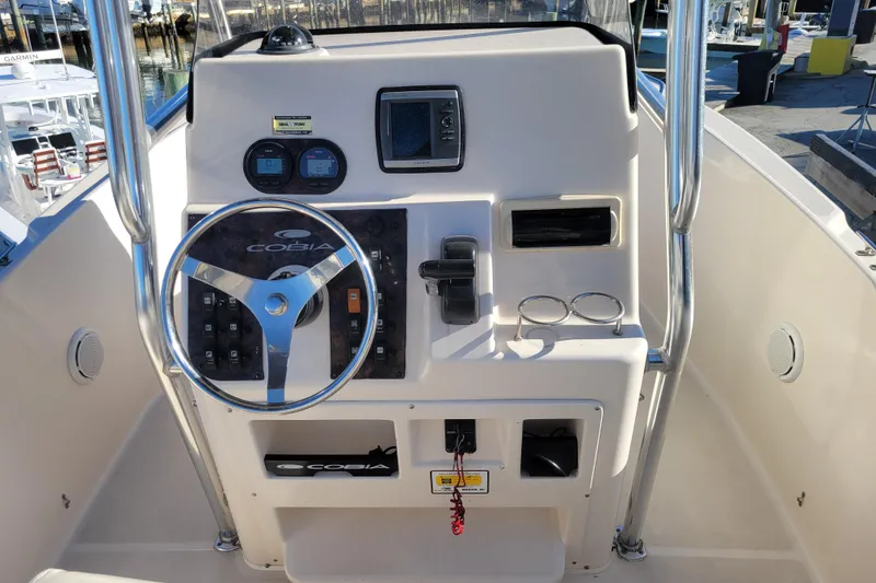 Slide: The Image of 2008 Cobia 235 Center Console boat dashboard with steering wheel and controls. - 5