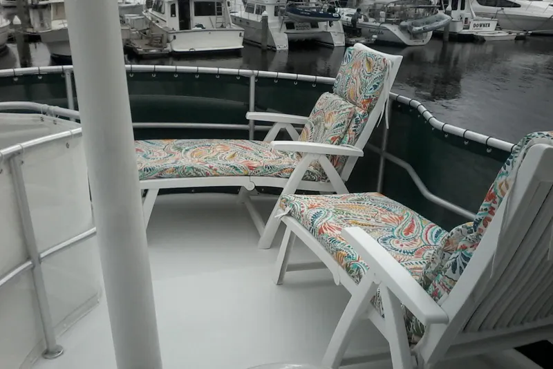 Slide: The Image of 1997 Mainship 350 yacht deck with colorful cushioned chairs in a marina setting. - 10