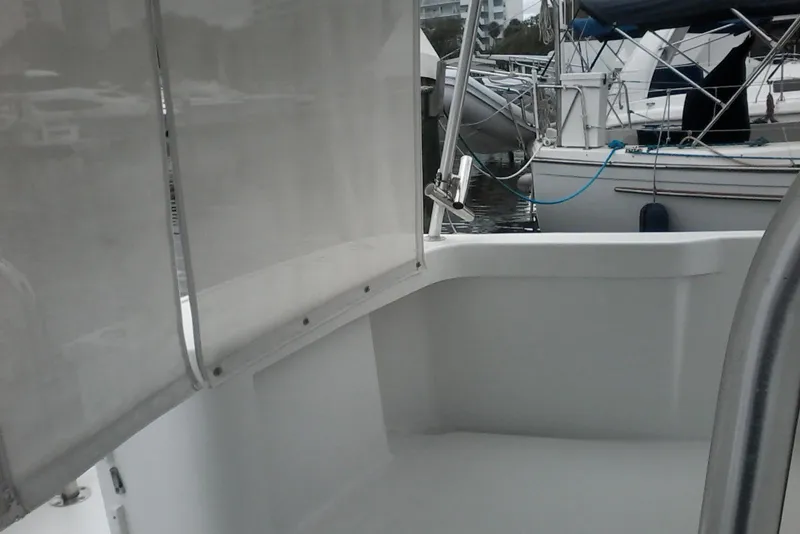 Slide: The Image of 1997 Mainship 350 boat interior with marina view, featuring clean white surfaces and docked vessels. - 16