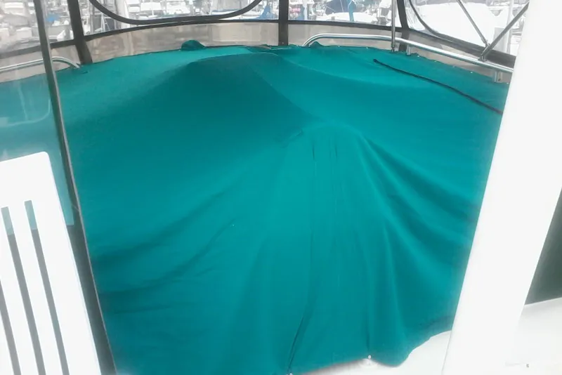 Slide: The Image of Covered deck area of a 1997 Mainship 350 boat with teal fabric. - 18