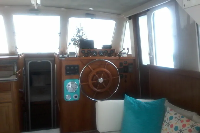 Slide: The Image of Interior of a 1997 Mainship 350 boat with wooden helm and cozy seating. - 23