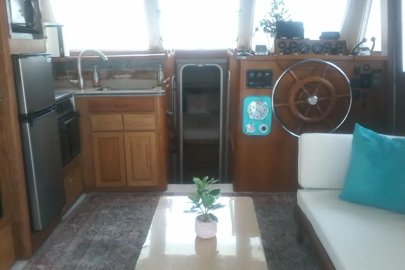 Slide: The Image of Interior of a 1997 Mainship 350 boat with helm, kitchen, and seating area. - 24