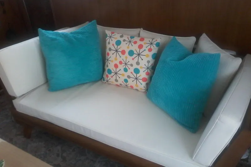 Slide: The Image of White couch with colorful and turquoise pillows, aboard a 1997 Mainship 350. - 26