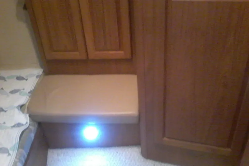 Slide: The Image of Interior of 1997 Mainship 350 boat with wooden cabinetry and cushioned seating. - 31