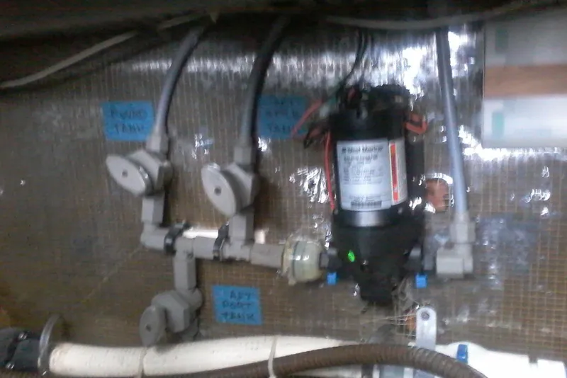 Slide: The Image of 1997 Mainship 350 boat plumbing system with labeled water tanks and pump. - 45