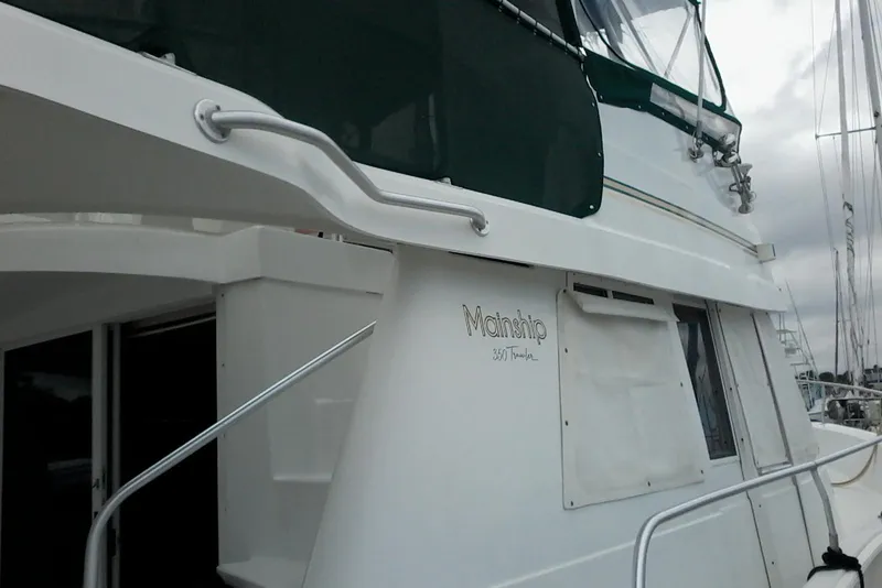 Slide: The Image of 1997 Mainship 350 yacht with white exterior and green canopy, docked at marina. - 5