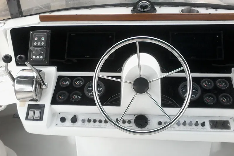 Slide: The Image of 1997 Mainship 350 helm with steering wheel, gauges, and controls. - 8