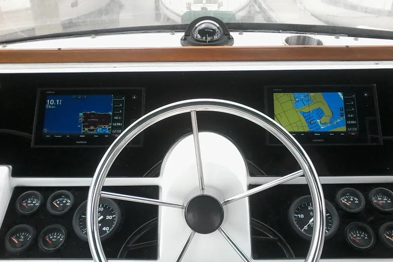 Slide: The Image of 1997 Mainship 350 helm with navigation screens and gauges, featuring a classic steering wheel. - 9