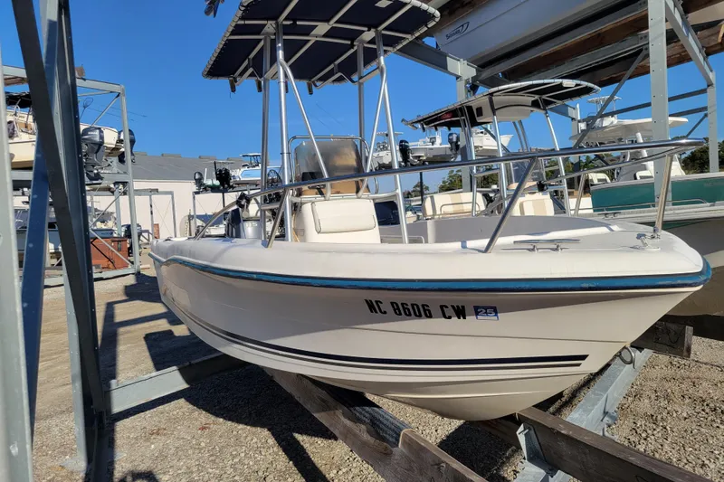Slide: The Image of 2004 Palm Beach 1860 boat on dry dock, featuring a blue canopy and white hull. - 3