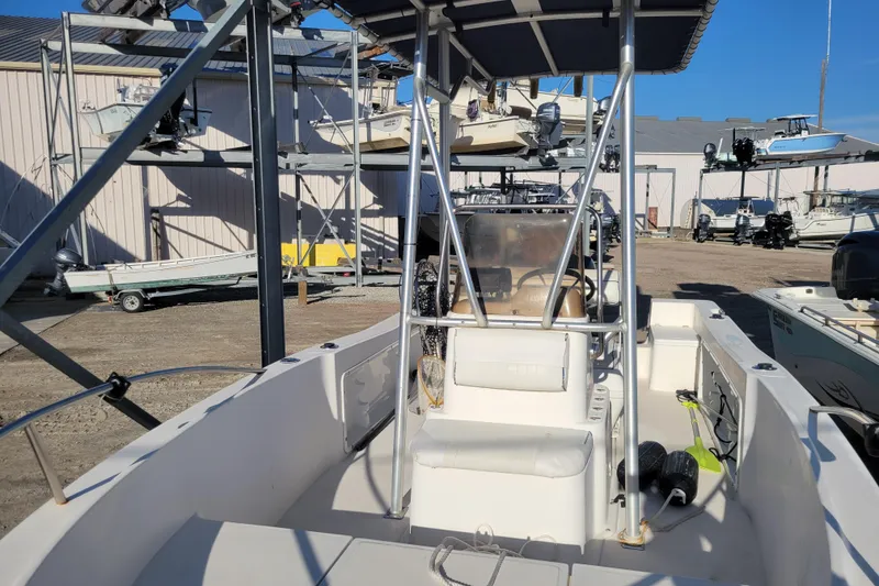 Slide: The Image of 2004 Palm Beach 1860 boat interior with seating and steering console in a marina setting. - 5