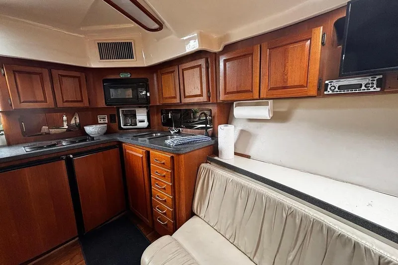 Slide: The Image of 2002 Luhrs 40 Open yacht interior with wooden cabinets and compact kitchen area. - 14