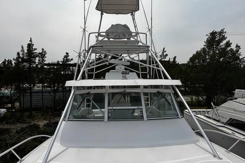 Slide: The Image of 2002 Luhrs 40 Open boat with tower, docked among trees and other vessels. - 23