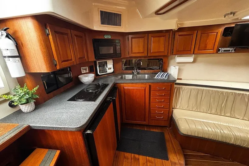 Slide: The Image of 2002 Luhrs 40 Open yacht interior with wooden cabinetry and modern kitchen amenities. - 8