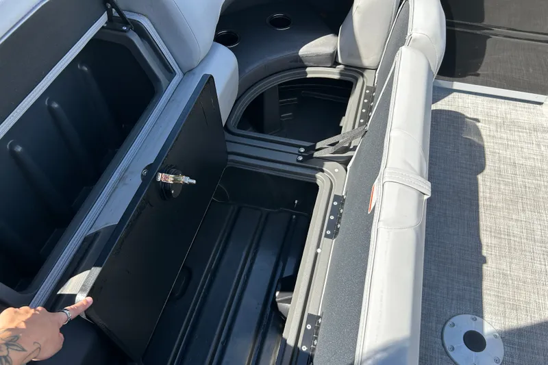 Slide: The Image of Sun Tracker Party Barge 24 XP3 storage compartment with open seat and visible interior. - 14