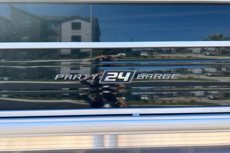 Slide: The Image of 2026 Sun Tracker Party Barge 24 XP3 logo on reflective surface. - 23