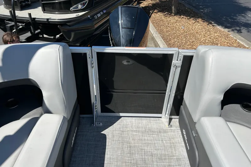 Slide: The Image of 2026 Sun Tracker Party Barge 24 XP3 interior with gray seating and open gate. - 16