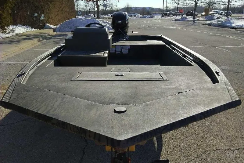 Slide: The Image of 2026 Tracker Grizzly 1648 SC boat in a snowy parking lot. - 2