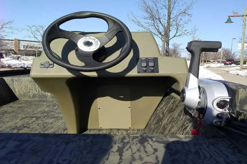 Slide: The Image of 2026 Tracker Grizzly 1648 SC boat steering console with control panel and throttle. - 3